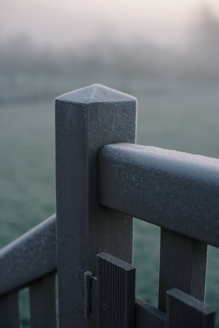 why-choose-us Close-up of a frost-covered wooden fence in a cold winter morning, showcasing nature's icy touch.