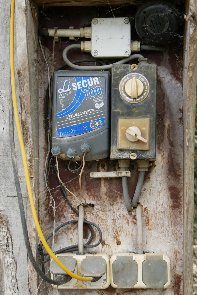 Home Close-up of a weathered electric control panel, showcasing vintage design outdoors.